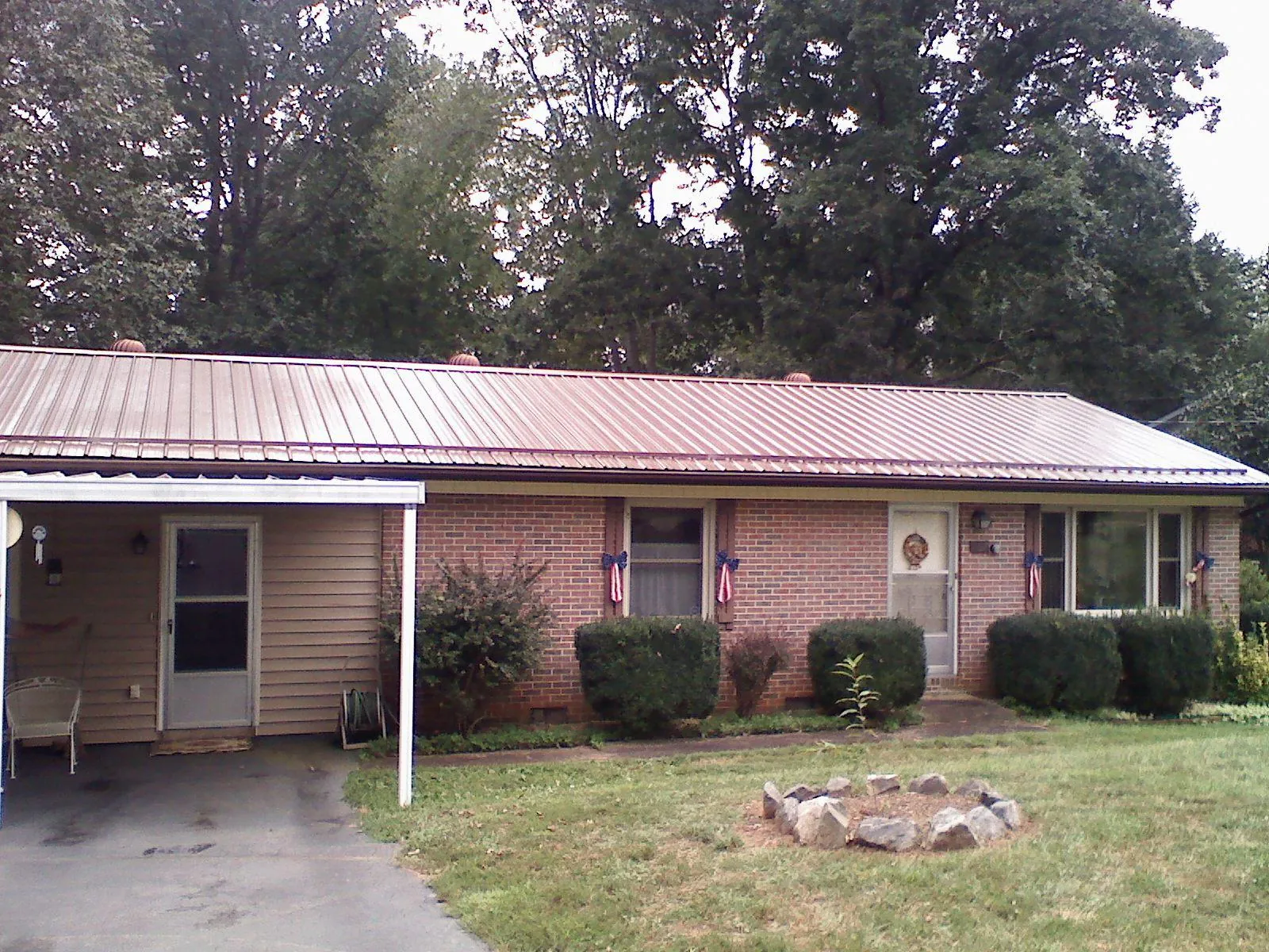 Bronze metal roof and carport on a brick ranch home — Roof Repair work by our crew in North Woodstock